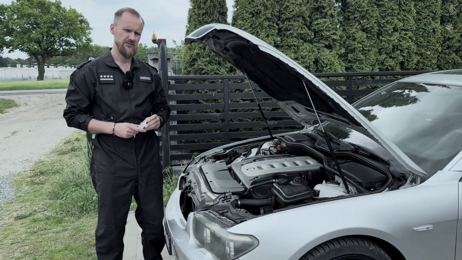 Właściciel warsztatu przy diagnostyce BMW z otwartą maską